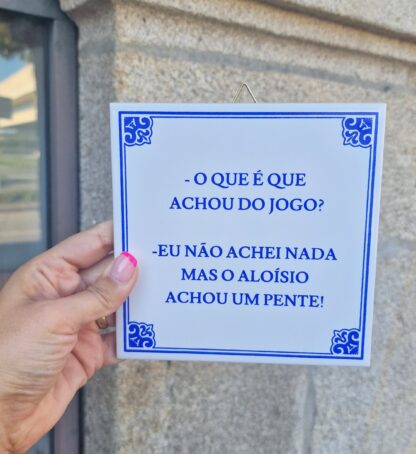 Azulejo "“- O que é que achou do jogo? - Eu não achei nada mas o Aloísio achou um pente!“"